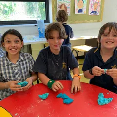 3 children smiling and moulding their experiment