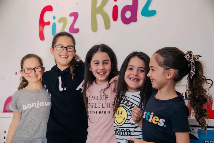 Kids arm in arm smiling