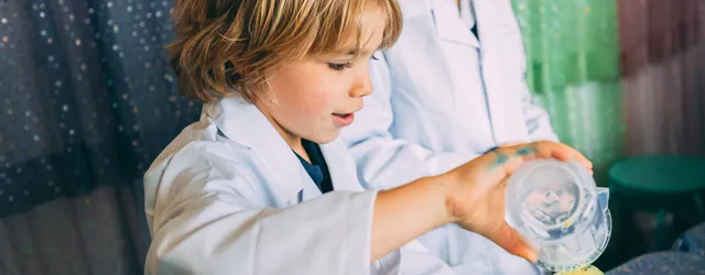 A kid in a lab coat pouring something