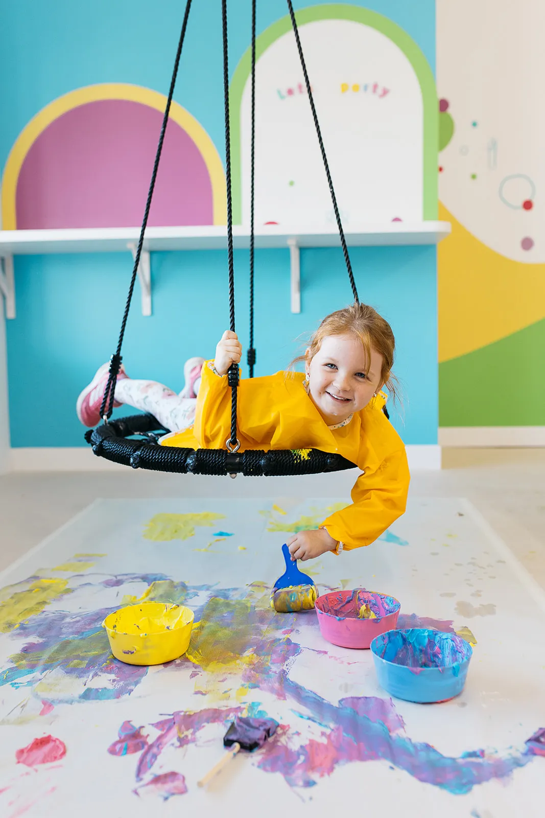 A girl amazed as she plays with paint