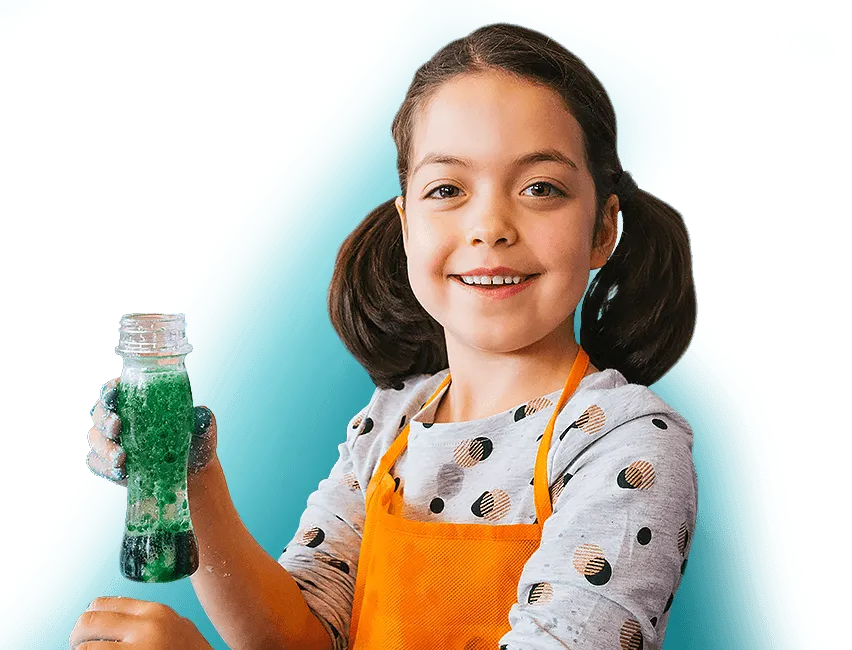 A girl smiling and holding a green bubbling volcano