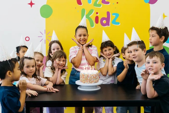 Kids smiling around a birthday cake