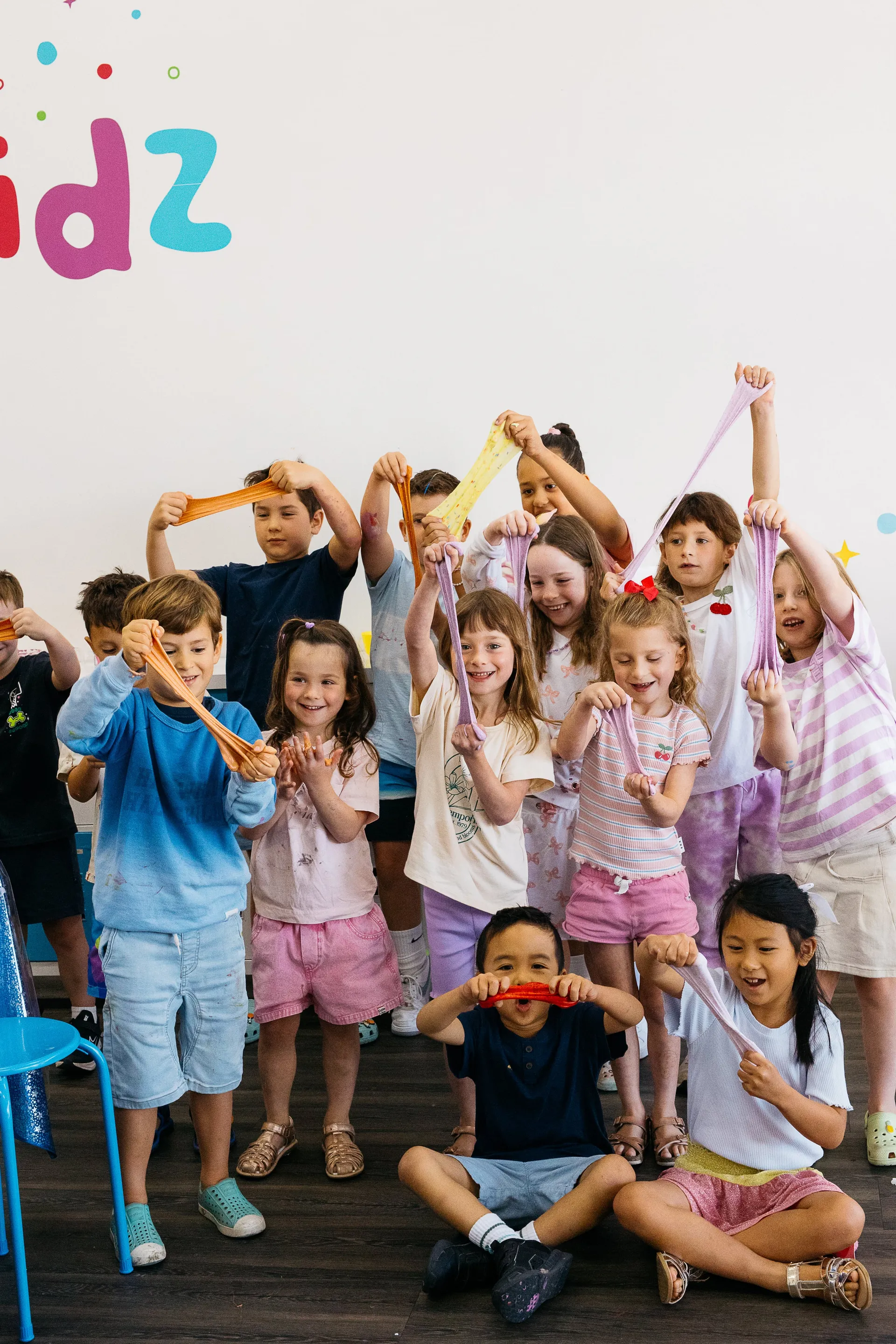 A child stretching colourful slime at Fizz Kidz