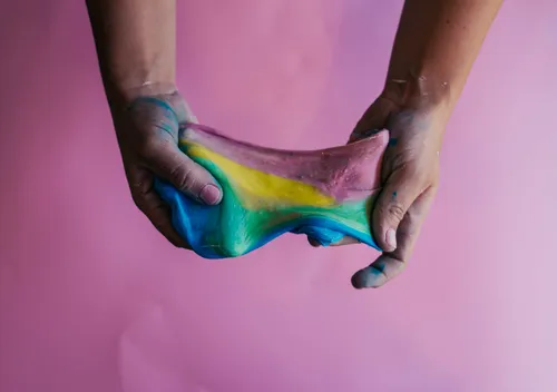 Rainbow slime in messy hands